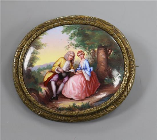 A gilt metal mounted mother of pearl oval panel, painted with lady and gentleman in woodland scene, 50mm.